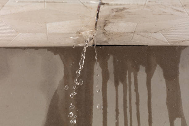 SwiftFix | Emergency Roof Repair in Edinburgh Heavy storm rain create water flow from edge of ceiling and dirty stain on wall. Water leaking from top ceiling as droplets and flow in old house